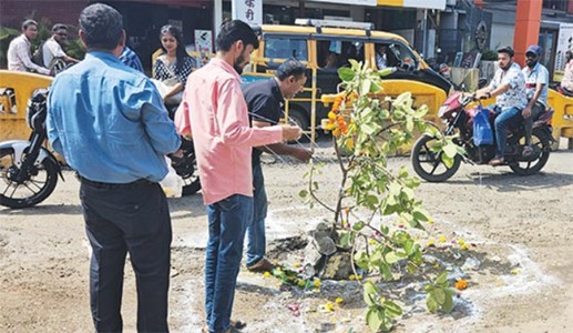 खड्ड्यांमुळे त्रस्त तरुणांनी भररस्त्यात केले वटपूजन